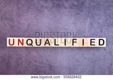 Text Unqualified Is Written On Wooden Building Blocks Lying On An Office Desk. Business Concept.