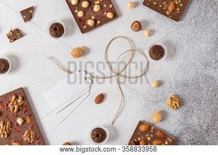 Homemade Milk Chocolate Bars And Pralines With Dried Berries And Nuts On Light Background. Top View.