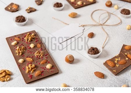 Handmade Milk Chocolate Bars With Nuts And Dried Fruits And Ingredients On White Background. Side Vi