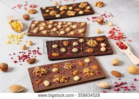 Homemade Milk And Dark Chocolate Bars With Dried Berries And Nuts On Light Background. Side View. Ch
