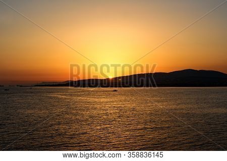 a sunset above the sea in the resort town of Gelendzhik, the sun is gradually left behind mountains. Black sea coast