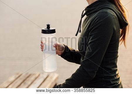 Beautiful Girl At Morning Workout Drinks Water From A Bottle