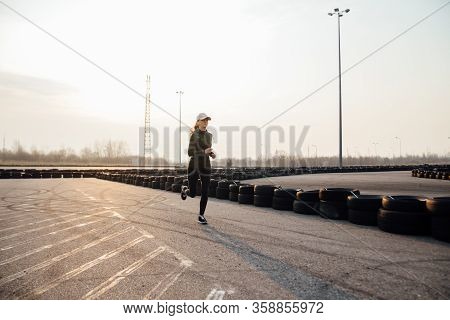 Morning Run Of A Young Girl On The Street In Black Leggings And Sneakers