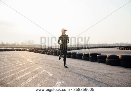 Morning Run Of A Young Girl On The Street In Black Leggings And Sneakers