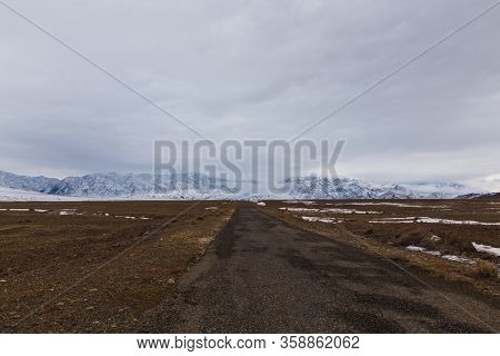 Empty Road To Bartogai Lake With Mountains In Background In Winter Time Near Almaty, Kazakhstan