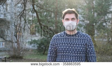 Young Man In White Medical Mask On The Street In The Period Of The Pandenic. Guy Take Off The Mask F