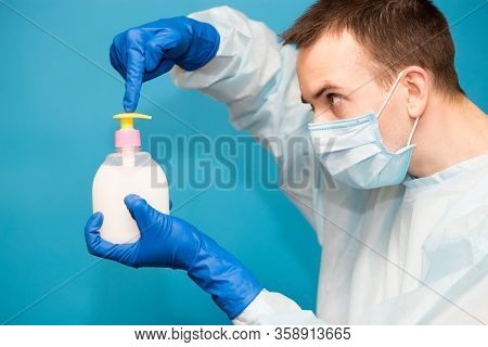 Doctor In Medical Suit Protective Mask And Gloves Washing Hands Before Operating Isolated On Blue Ba