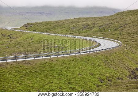Twisty Scenic Road With Green Landscape In Faroe Islands. Drive