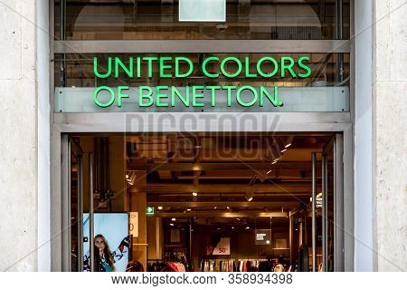 Siracusa, Sicily - February 12, 2020: The Green Logo Of United Colors Of Benetton Fashion Store Abov
