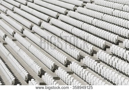 Rows Of White Empty Plastic Seats In A Stadium.