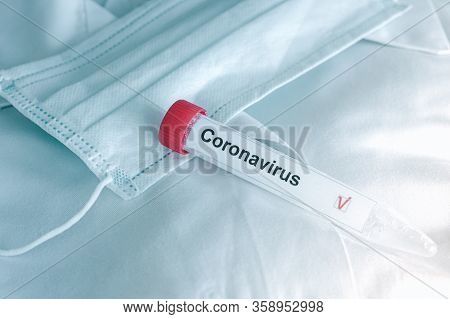 Coronavirus Test. Test Tube Lying On Inspiratory Protective Respiratory Mask. Covid-19 Test Or Sars-