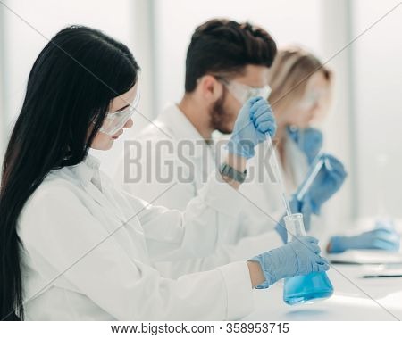 Close Up.modern Woman Sitting With Colleagues At The Laboratory