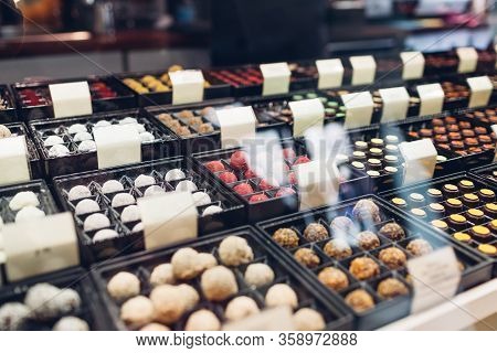 Assortment Of Candies Desserts On Cafe Showcase. Variety Of Sweets With Different Flavours Nuts In S