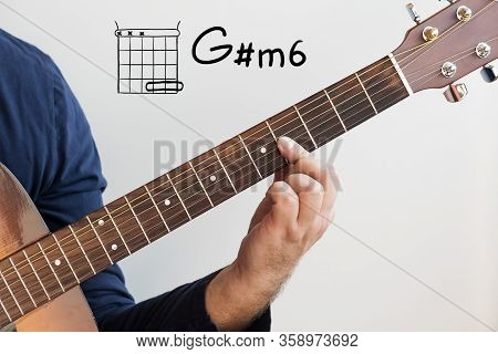 Learn Guitar - Man In A Dark Blue Shirt Playing Guitar Chords Displayed On Whiteboard, Chord G Sharp