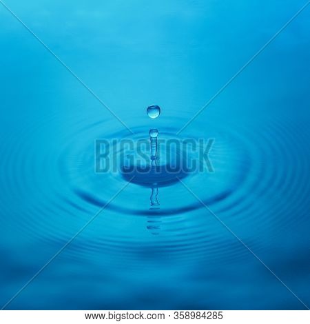 Splash From A Drop Of Water On A Blue Background, Close-up. Selective Focus.