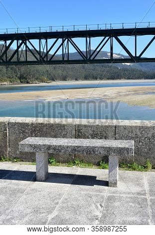 Beach With Forest, Promenade With Stone Bench And Train Bridge Over Sor Coastal River. O Barqueiro, 