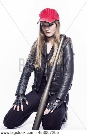 Caucasian Female Baseball Player Athlete Posing With Bat Sitting On Hunkers While Wearing Red Cap An