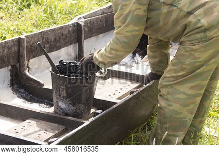 Repair Of A Wooden Boat.a Man Is Engaged In Repairing A Wooden Boat.