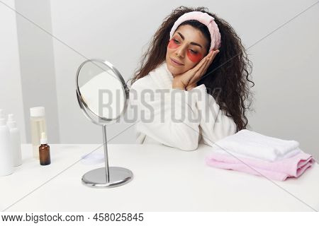 Lovely Happy Tanned Pretty Curly Latin Lady With Pink Patch For Eye Admiring Herself Reclines On Han