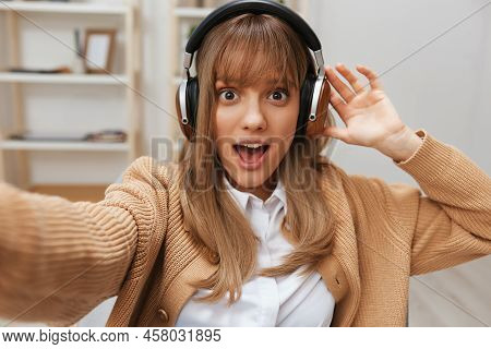 Excited Young Blonde Student Lady Freelancer In Warm Sweater In Headphones Listen Fav Songs Sitting 