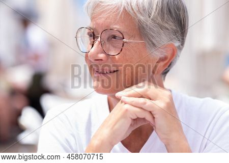 Portrait Of Beautiful Senior Mature Woman Sitting At Outdoor Restaurant Table Looking Away