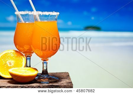 Dos tudeles de Tequila Sunrise cóctel en una mesa de playa cerca de Comentarios. Tener una pausa
