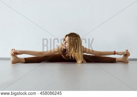 Young Attractive Fitness Woman Performing Twine , Upavista Konasana