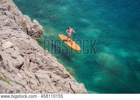 Young Women Having Fun Stand Up Paddling In Blue Water Sea In Montenegro. Sup. Girl Training On Padd
