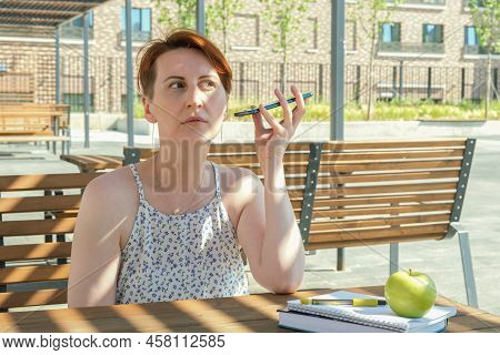 Woman With Short Hair Holds A Smartphone Near Her Ear And Listens To A Voice Message