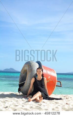 smiling young girl sits on white beach