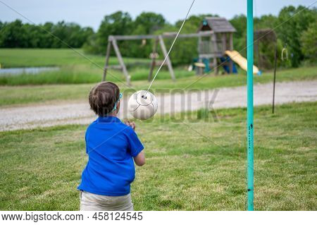 Tetherball Being Hit And Roped In A Game With A Young Boy.