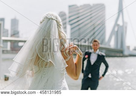 Bride And Groom Near The Water Near The Bridge And The Big City