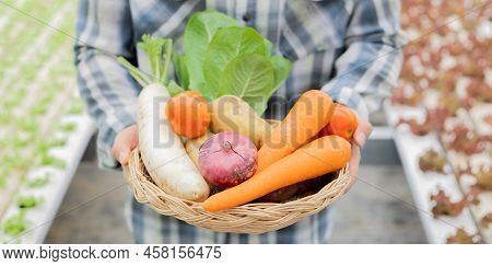 Farmer Holding A Basket Of Organic Vegetables.