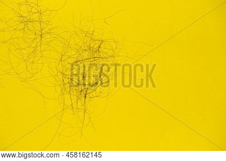Fallen Hair On The Yellow Background. Baldness And Hair Loss Problem
