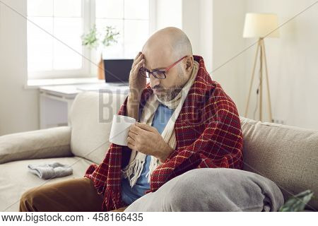 Unhappy Joyless Sick Man At Home Treats Flu And Colds With Medicinal Drink With Unpleasant Taste.