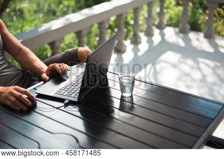 Working At A Laptop In The Outdoor Courtyard - Men\'s Hands Close-up. Home Office, Remote Work, Remo