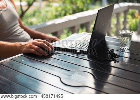 Working At A Laptop In The Outdoor Courtyard - Men\'s Hands Close-up. Home Office, Remote Work, Remo