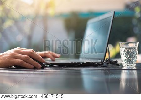 Working At A Laptop In The Outdoor Courtyard - Men\'s Hands Close-up. Home Office, Remote Work, Remo