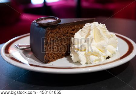 Piece Of Famous Sachertorte Chocolate Cake With Apricot Jam Of Austrian Origin Served In Traditional