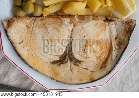 Seafood Dish, Grilled Steak From Swordfish Or Spada Served With French Fried Potatoes And Green Oliv
