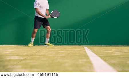 Padel Player With Black Racket Playing A Match In The Open Behind The Net Court