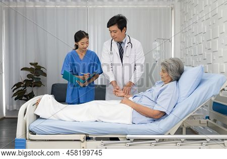 Senior Female Patient And Doctor. Asian Doctor With Stethoscope Check The Pules Of The Elderly Patie