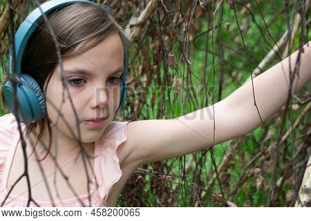 Girl Around With A Branch And Wearing Headphones