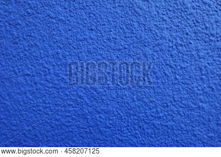 Close View Of Wall With Coarse Vibrant Blue Roughcast Finish