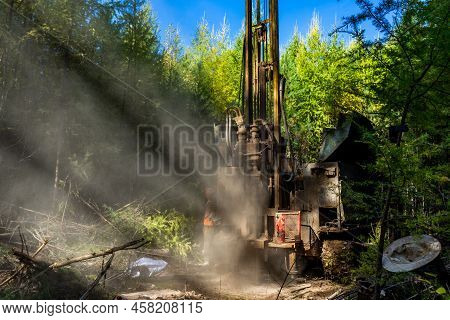 Working Process Of Drilling A Geological Well. Dust When Drilling Borehole. Drilling Rig In The Fore