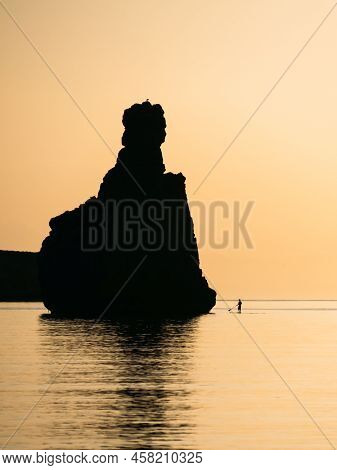 Silhouette Of A Man Floating On A Supboard At Sunset In Ibiza