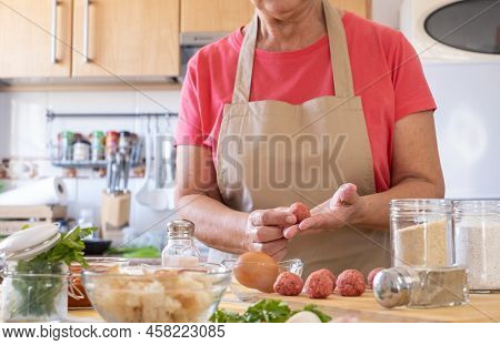 Woman Preparing Meatballs With Raw Materials To Mix For Cooking, Home Kitchen, Wooden Cutting Board