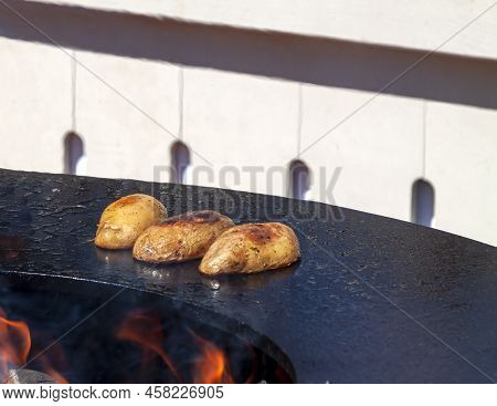 Big Slice Of Village-style Potatoes On Hot Bbq Charcoal Grill. Fire Flames With White Black Backgrou