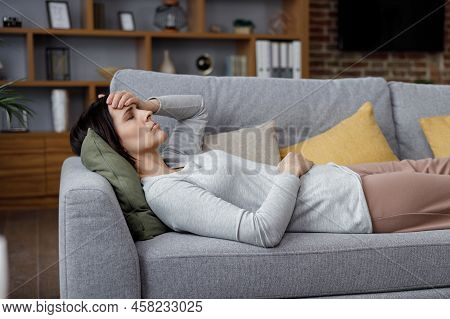 Upset Young Woman Suffering From Headache. Exhausted Woman With Closed Eyes Massaging The Temples Ha