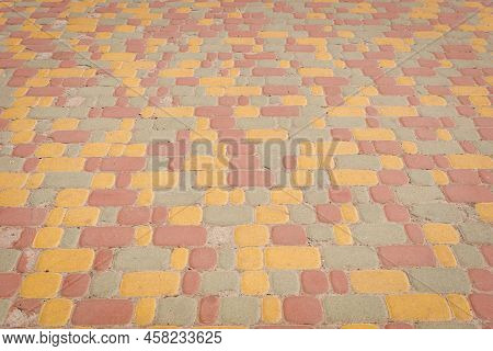 Background Of Colorful Cobblestone Pavement Closeup. Multi-colored Tiles Paving For Texture. Broken 